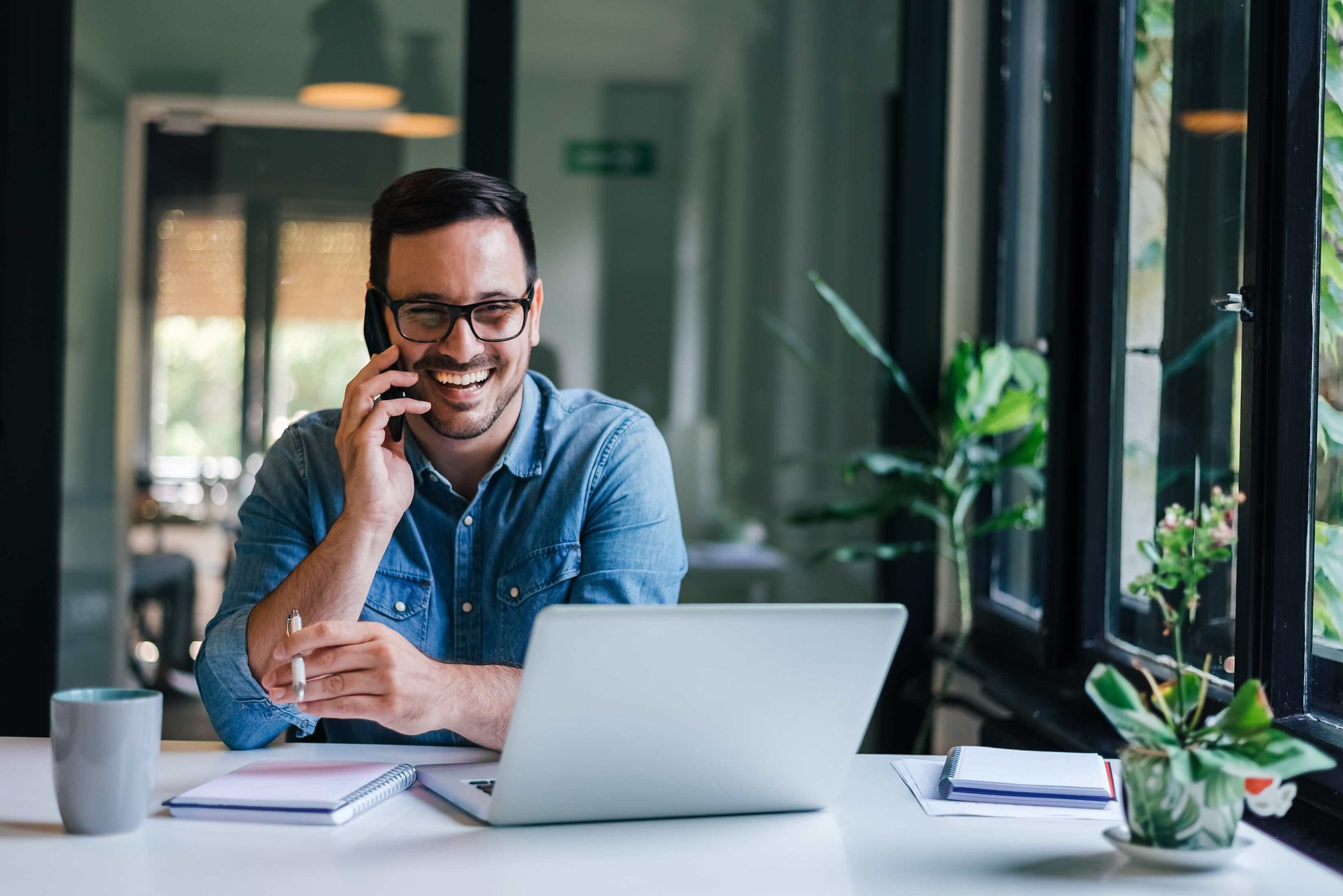 man talking on a phone as he works from home